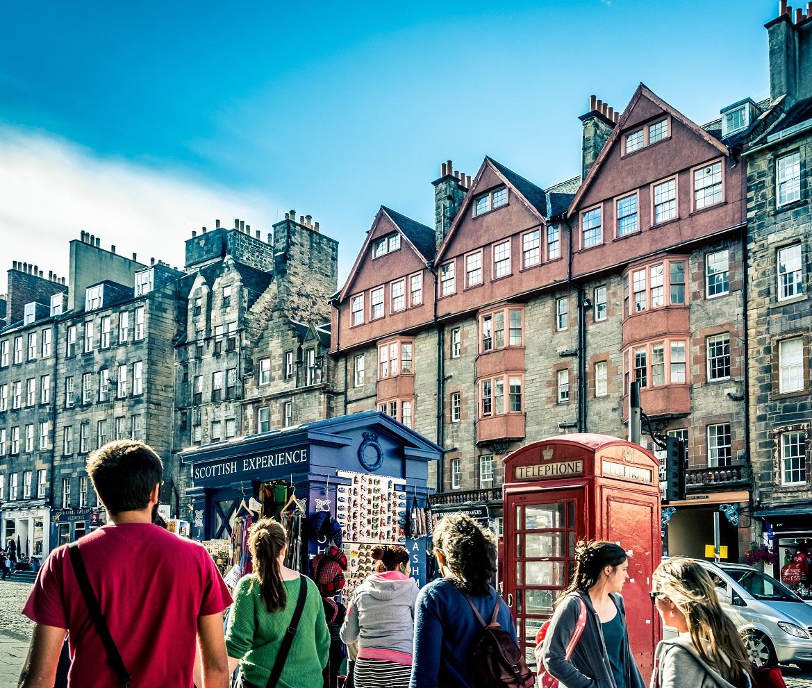 People walking down a street with historic buildings in the background.