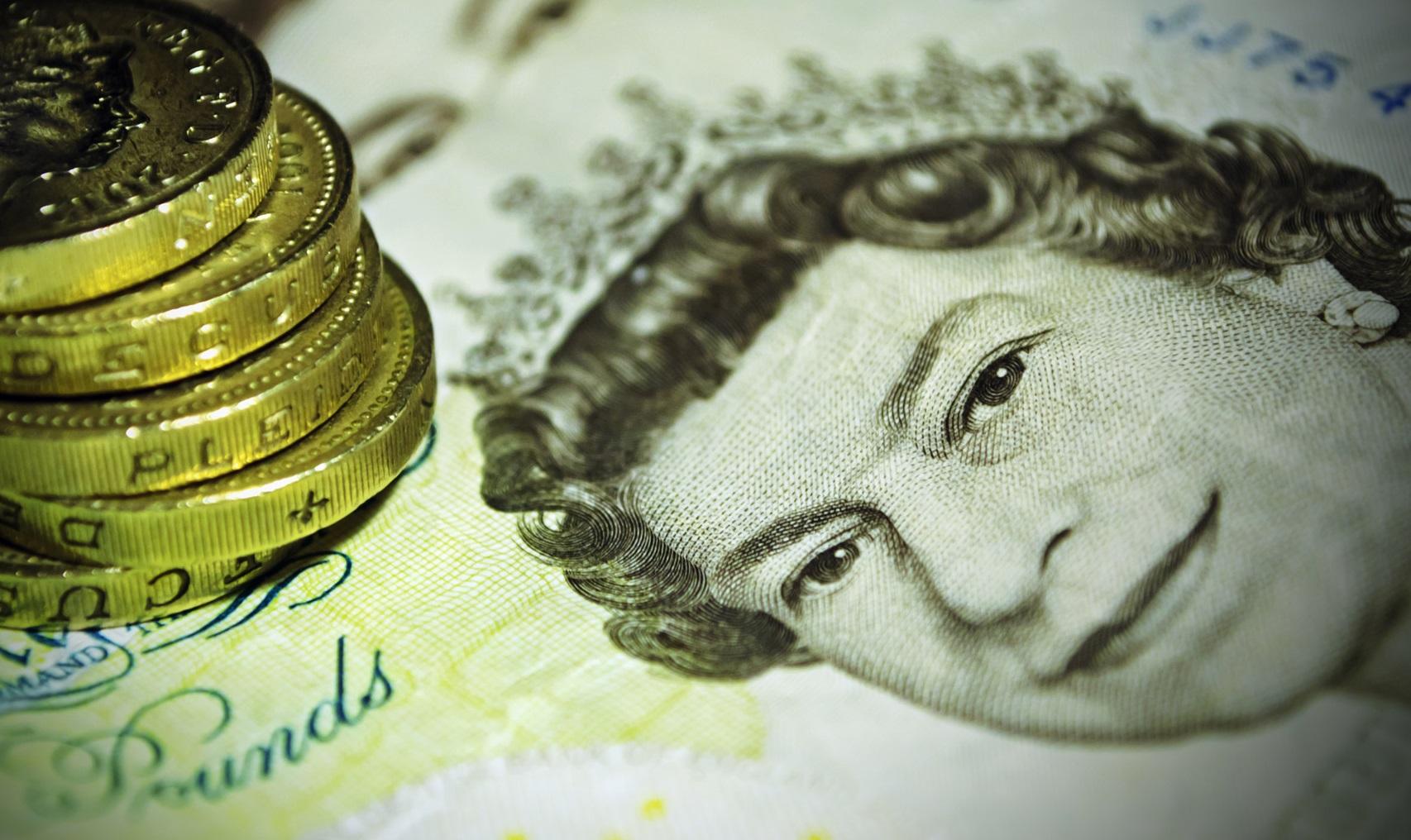 A close up of notes and coins (pounds sterling).